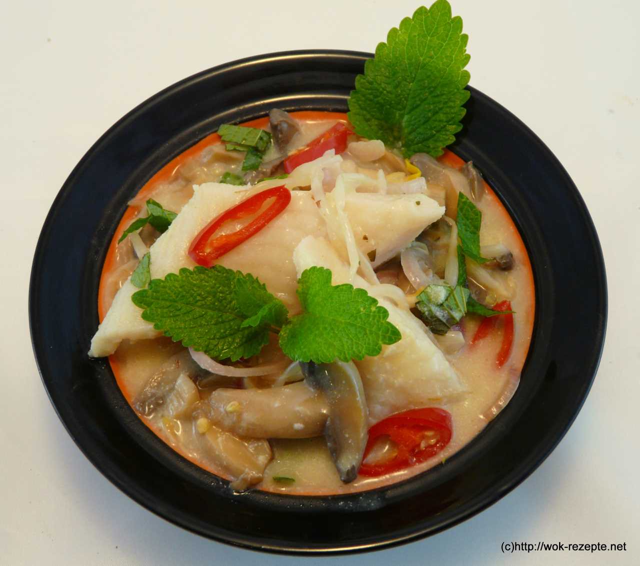 Asiatische Kokossuppe mit Fischstücke und Champignon.